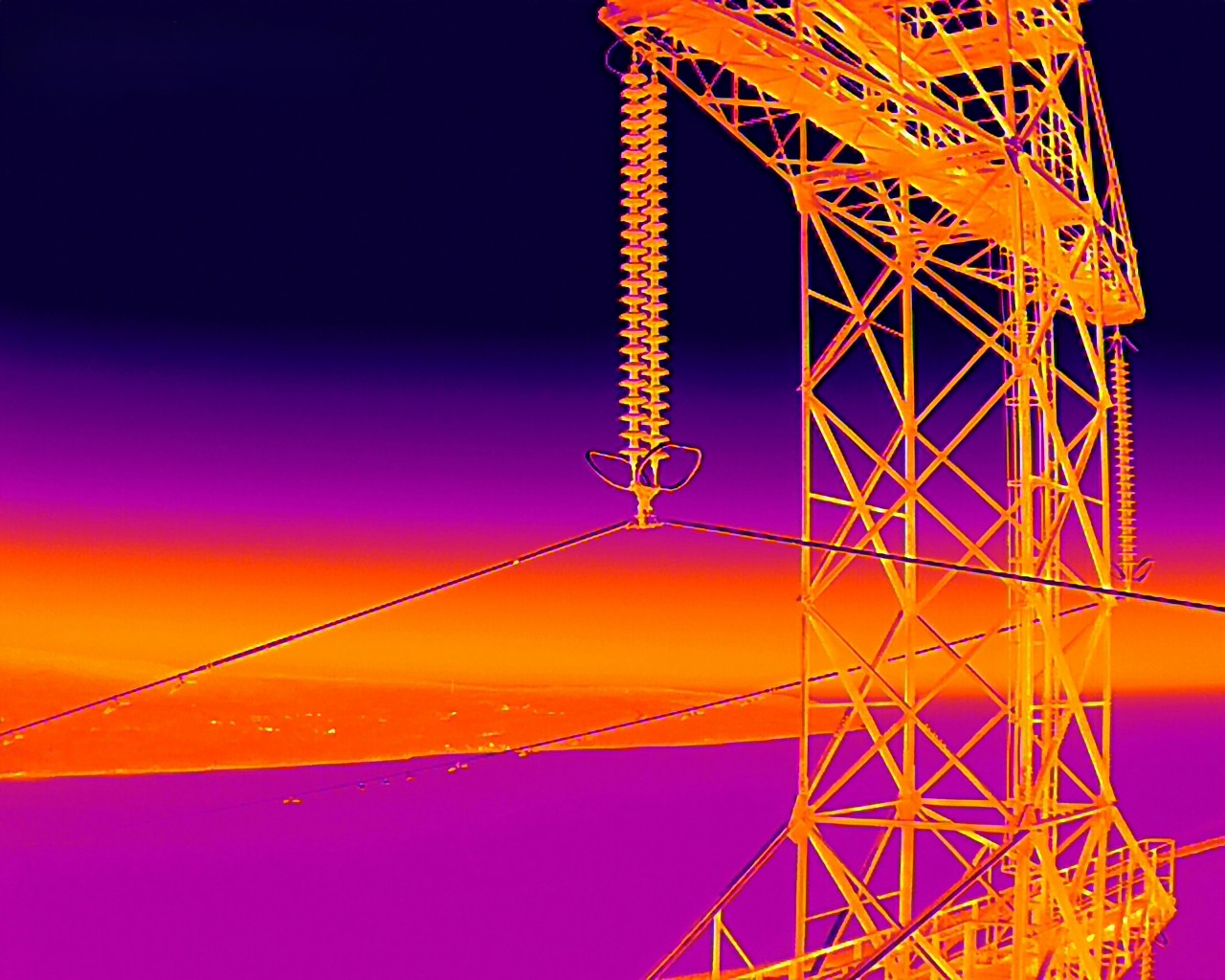 Thermal imaging of an electrical transmission tower with a purple and orange gradient background.