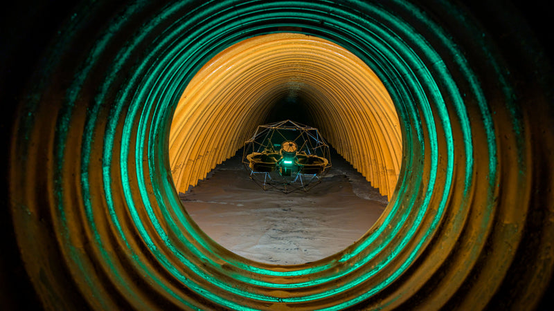 Elios-3 navigating a tunnel with green and yellow lighting