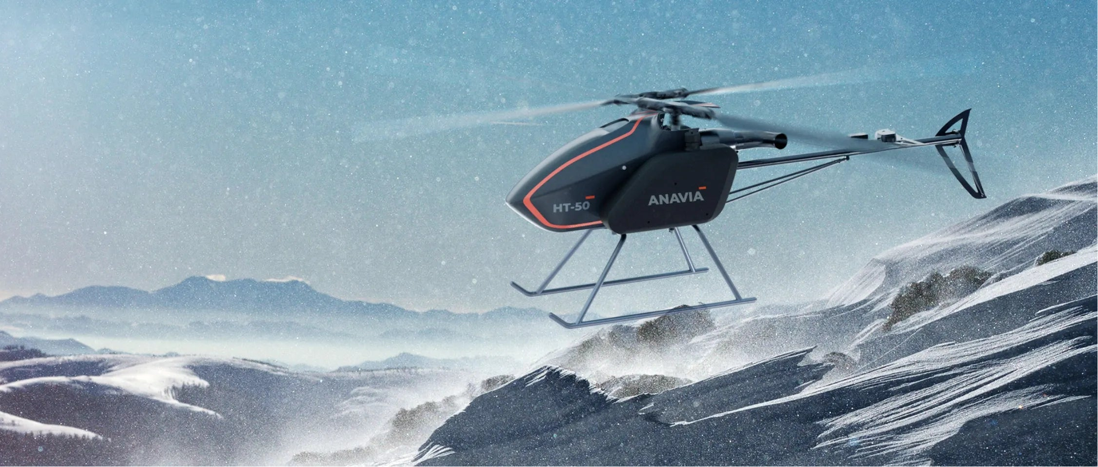 HT-50 flying over a snowy landscape with mountains in the background